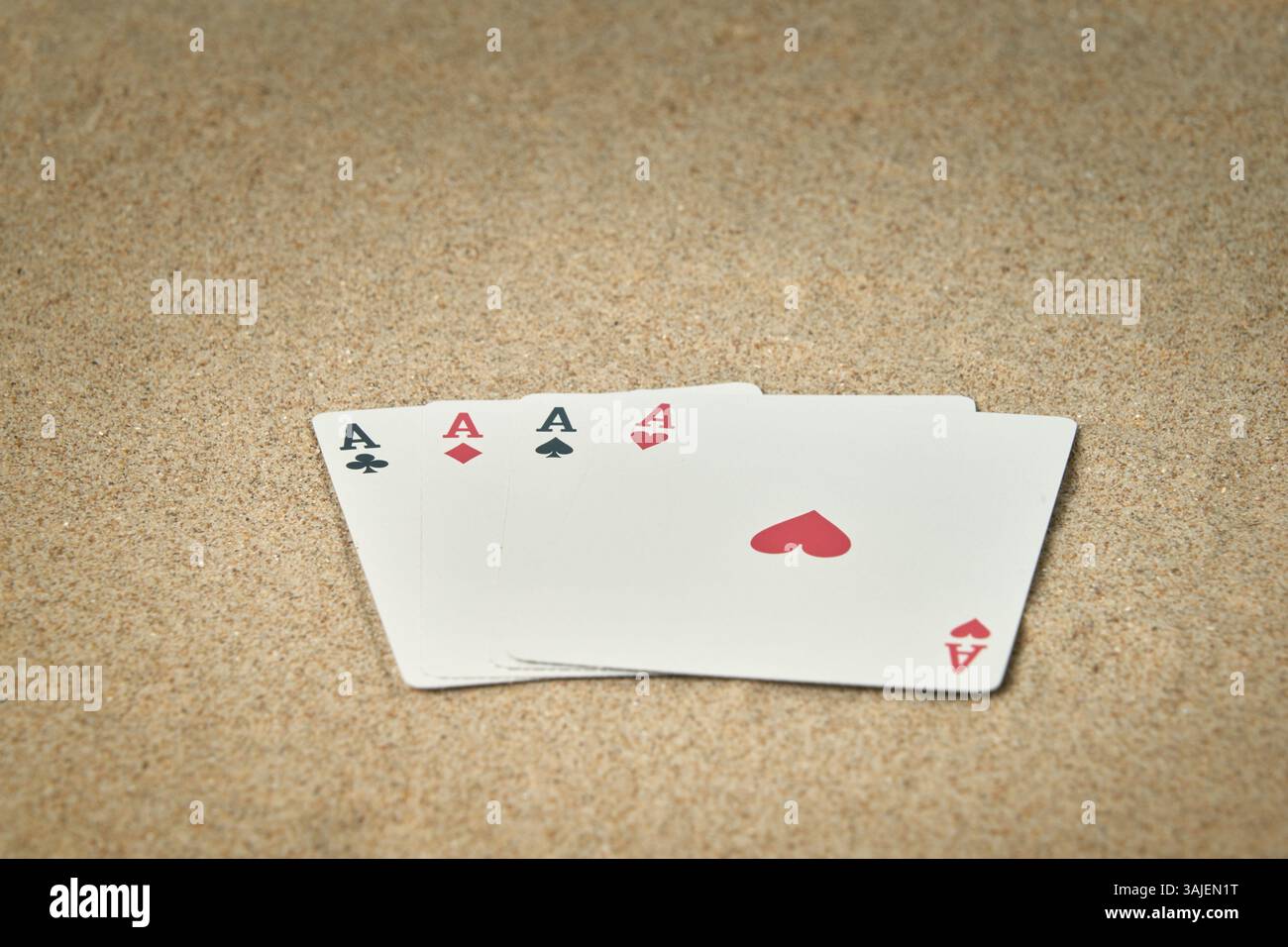 Quattro assi dal mazzo di poker sulla spiaggia e perfetti per sfondi con spazio per i testi Foto Stock