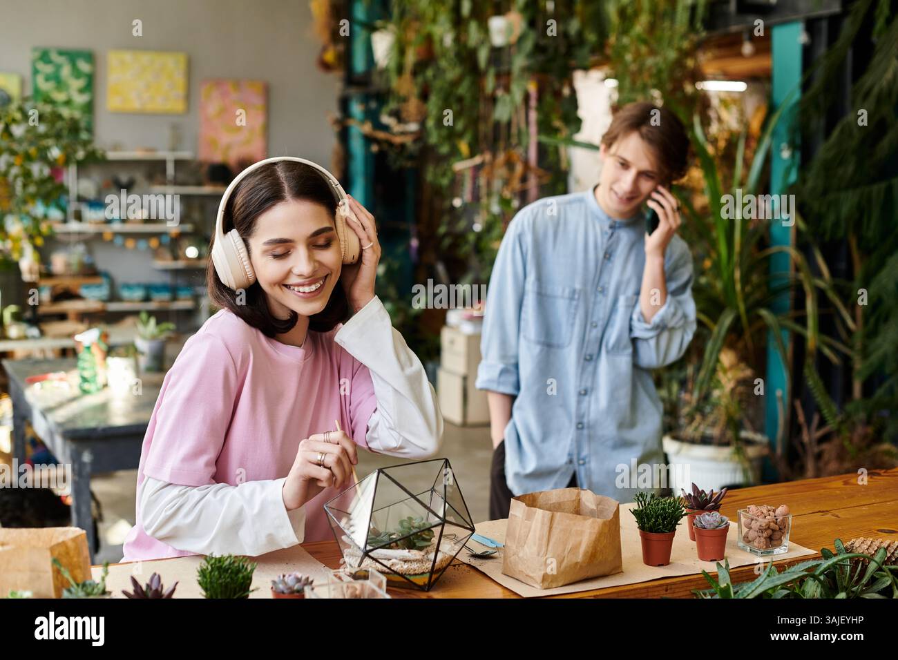 Le coppie amorevoli si impegnano in attività artistiche circondate da piante vivaci ed espressioni creative. Foto Stock