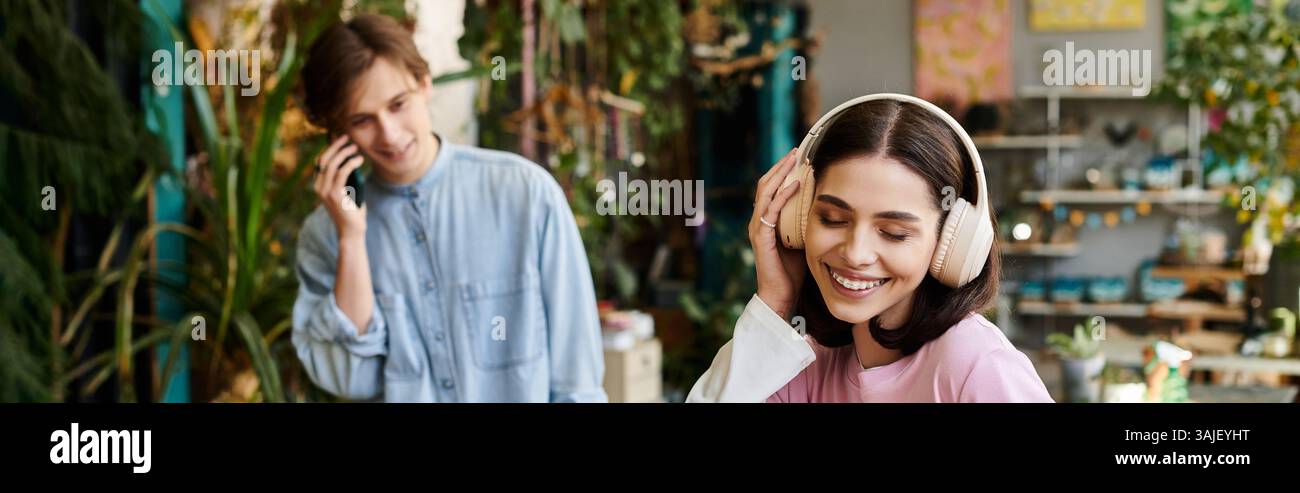 Giovani coppie creano arte in un vivace studio pieno di verde. Foto Stock