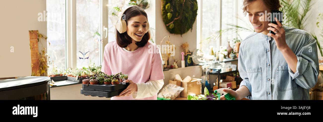 Le coppie creative si prendono cura delle loro piante, creando un ambiente vivace e creativo. Foto Stock