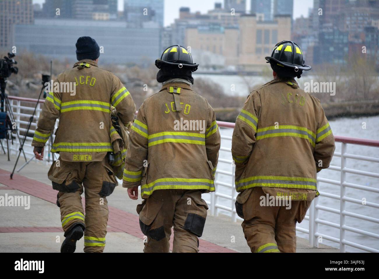 I soccorritori camminano lungo il fiume Hudson dopo un mortale incidente in elicottero tra Manhattan e Jersey City, New Jersey. Foto Stock