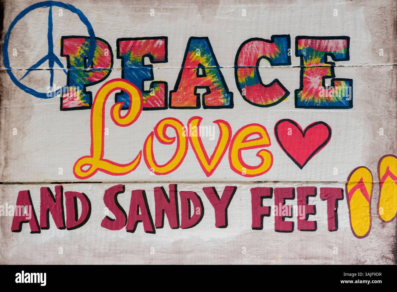 Cartello "Peace, Love, and Sandy Feet" con infradito. Foto Stock