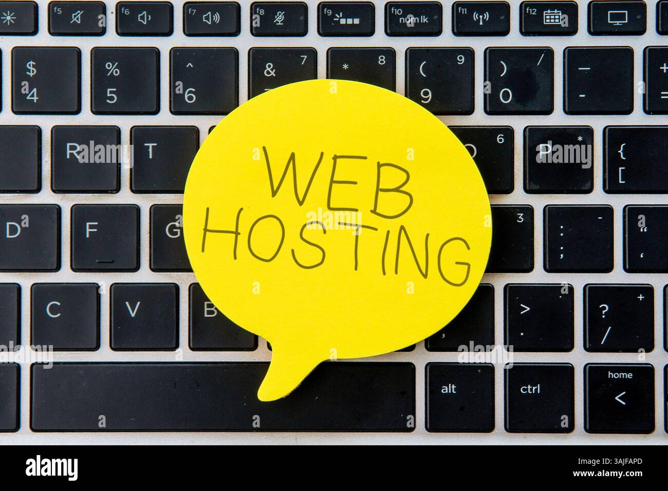 Bolla vocale gialla sulla parte superiore della tastiera del notebook con HOSTING WEB di testo. Business e tecnologia. Foto Stock