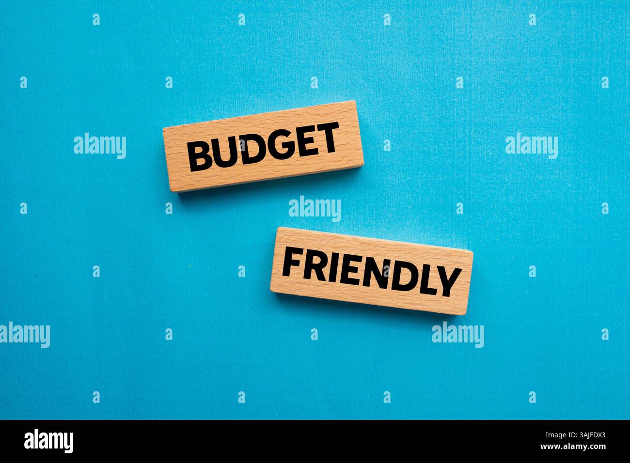 Messaggio economico scritto su blocchi di legno su sfondo blu. Simbolo di budget concettuale. Copia spazio. Foto Stock
