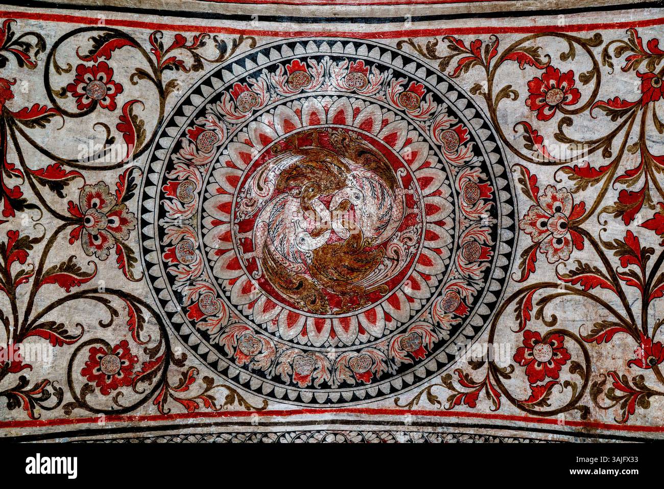 Un intricato murale tradizionale all'interno dello Sri Lankathilake Rajamaha Viharaya a Daulagala, Sri Lanka, caratterizzato da dettagliati motivi floreali e arte simbolica Foto Stock
