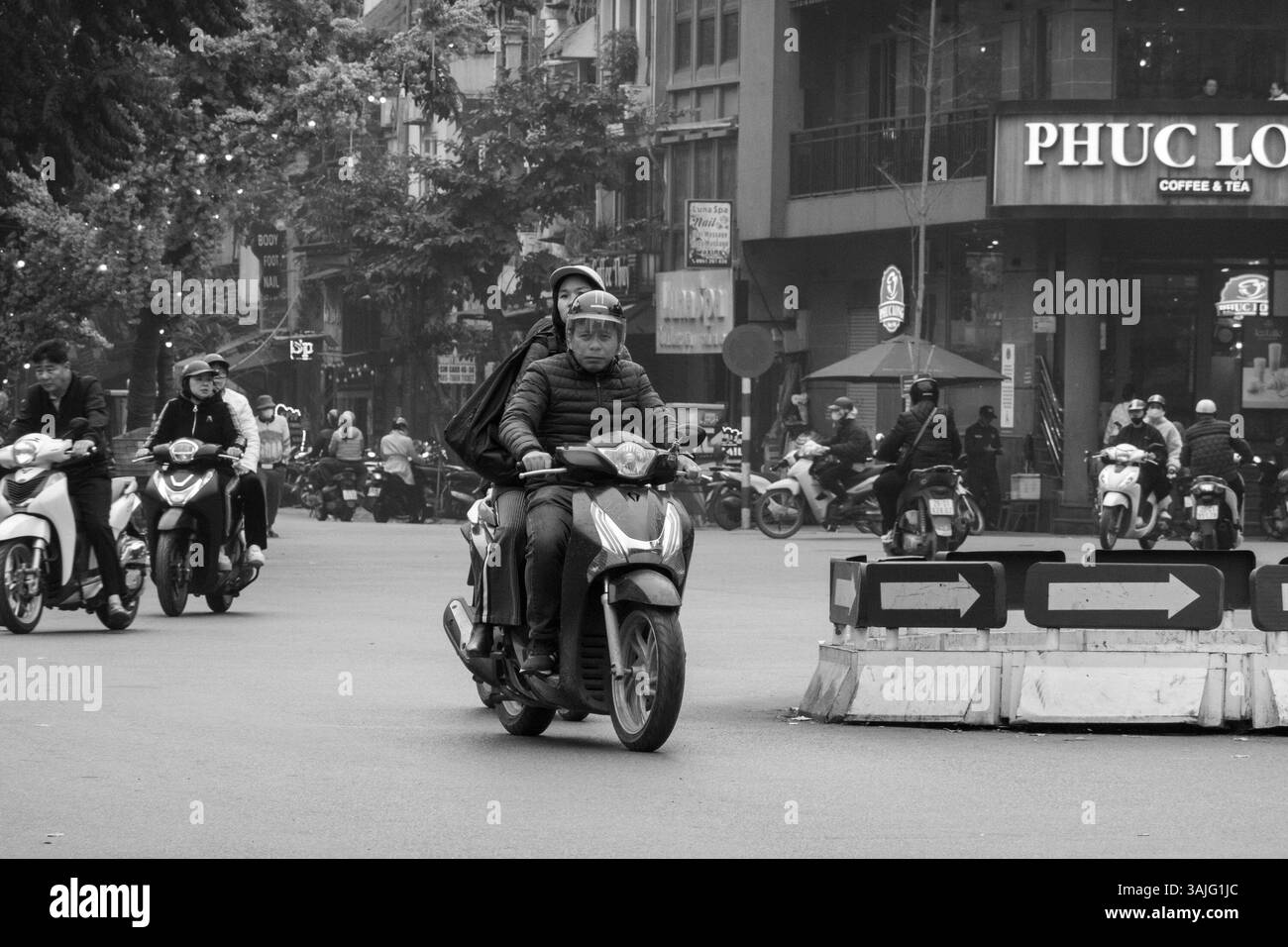 Le persone viaggiano in moto vicino al quartiere francese di Hanoi, Vietnam. Foto Stock