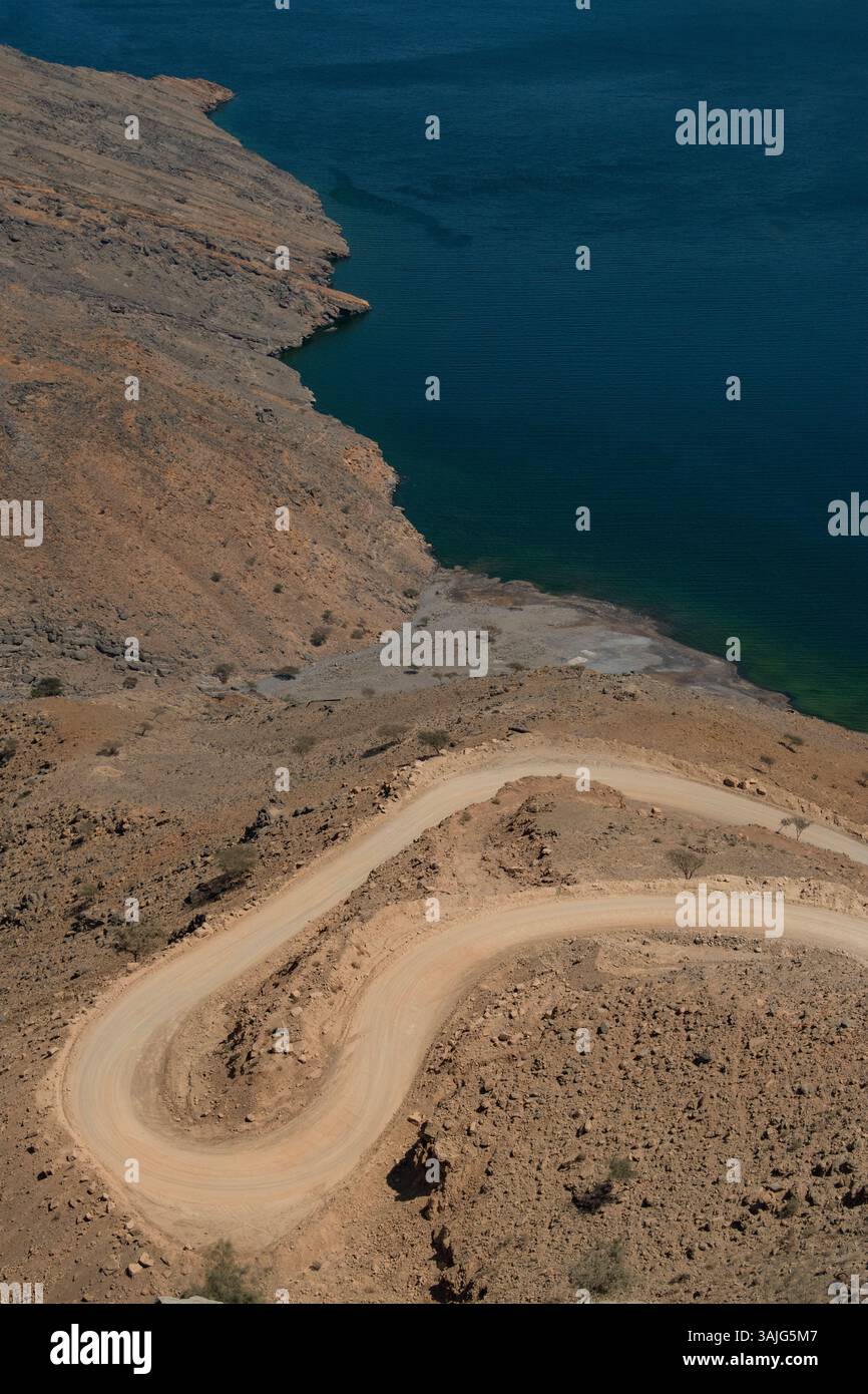 Oman: Vista aerea della tortuosa strada per Khor Najd, splendido fiordo nella penisola di Musandam, conosciuta per la sua bellezza naturale e la bioluminescenza delle sue acque Foto Stock