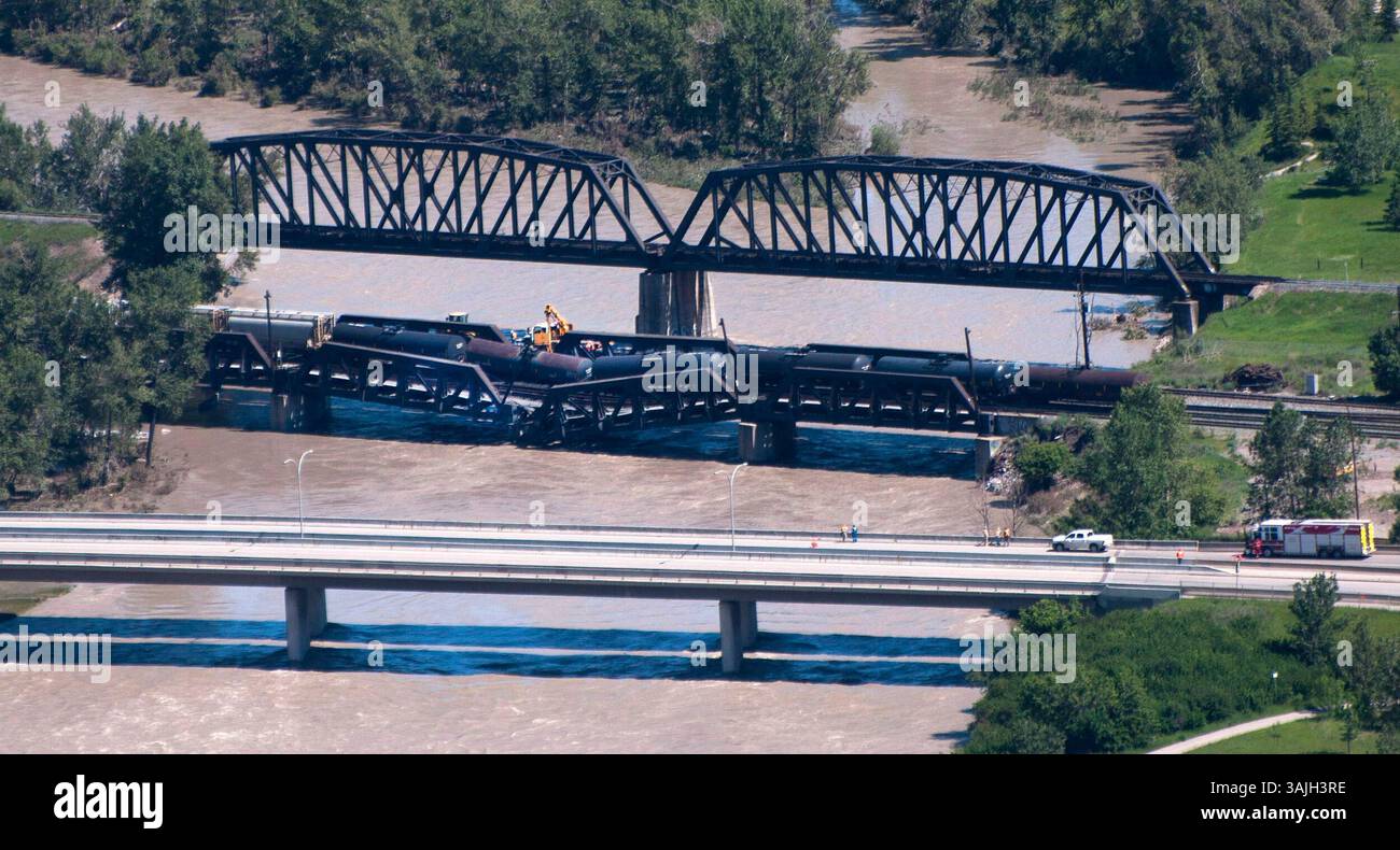 27 giugno 2013 - Calgary, Alberta, Canada - gli equipaggi lavorano sul luogo del crollo di un ponte ferroviario e del deragliamento delle automotrici sul fiume Bow, a sud-est del centro di Calgary, Alberta, giovedì. (Immagine di credito: © Larry MacDougal via ZUMA Wire) Foto Stock