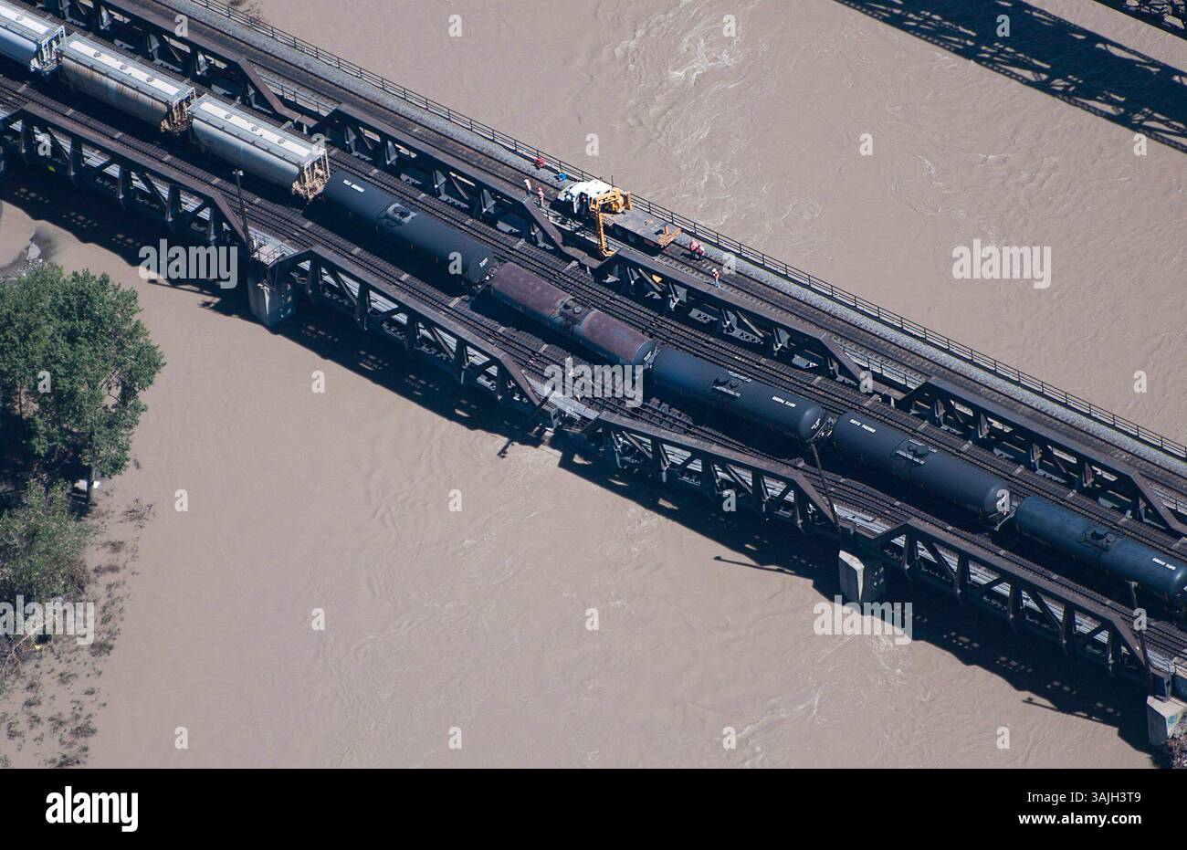 27 giugno 2013 - Calgary, Alberta, Canada - gli equipaggi lavorano sul luogo del crollo di un ponte ferroviario e del deragliamento delle automotrici sul fiume Bow, a sud-est del centro di Calgary, Alberta, giovedì. (Immagine di credito: © Larry MacDougal via ZUMA Wire) Foto Stock