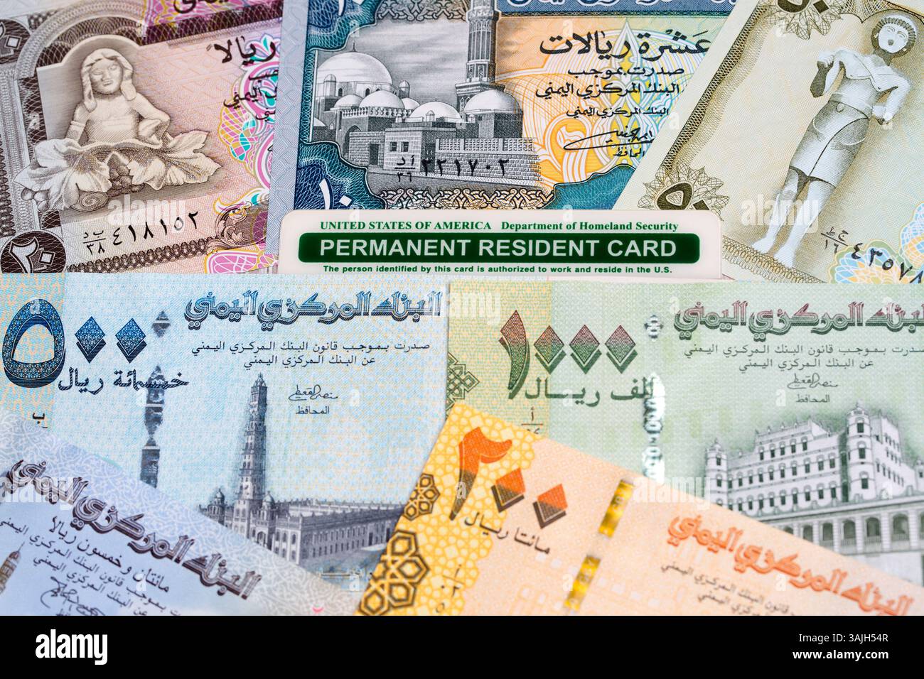 Carta residente permanente americana su un denaro yemenita - Rial Foto Stock