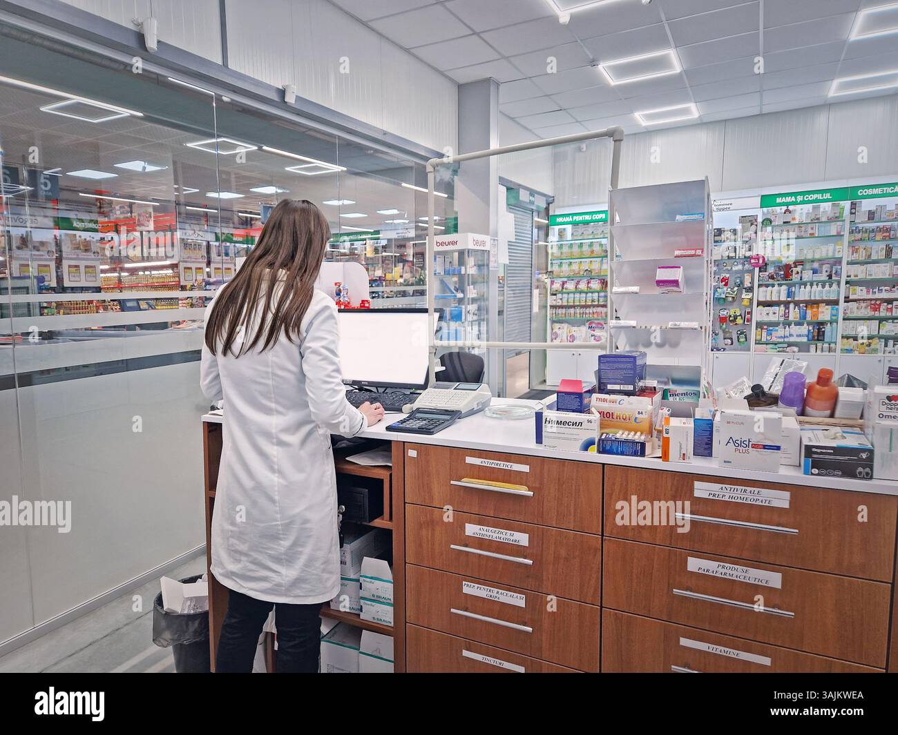 UNGHENI, MOLDAVIA - 20 GENNAIO 2024 vista all'interno della farmacia con una donna farmacista che lavora al banco di vendita di fronte al computer. Medi farmacia - Immagine stock catturata con smartphone