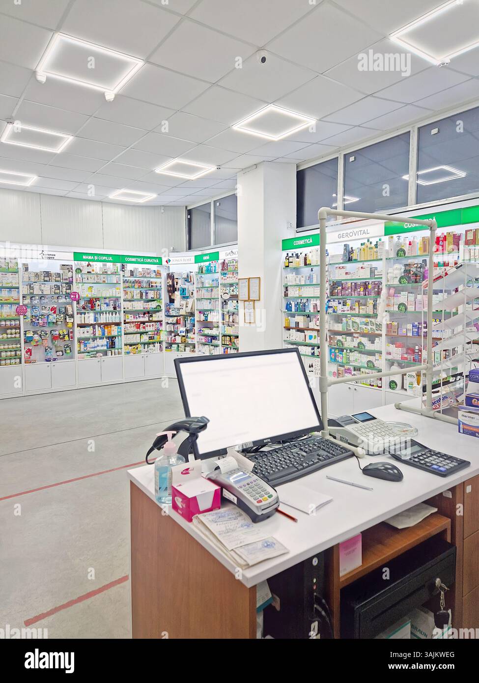 UNGHENI, MOLDAVIA - 20 GENNAIO 2024 Guarda all'interno di una farmacia con il bancone dei venditori, il computer e il registratore di cassa contro scaffali riforniti di medicinali. - Immagine stock catturata con smartphone