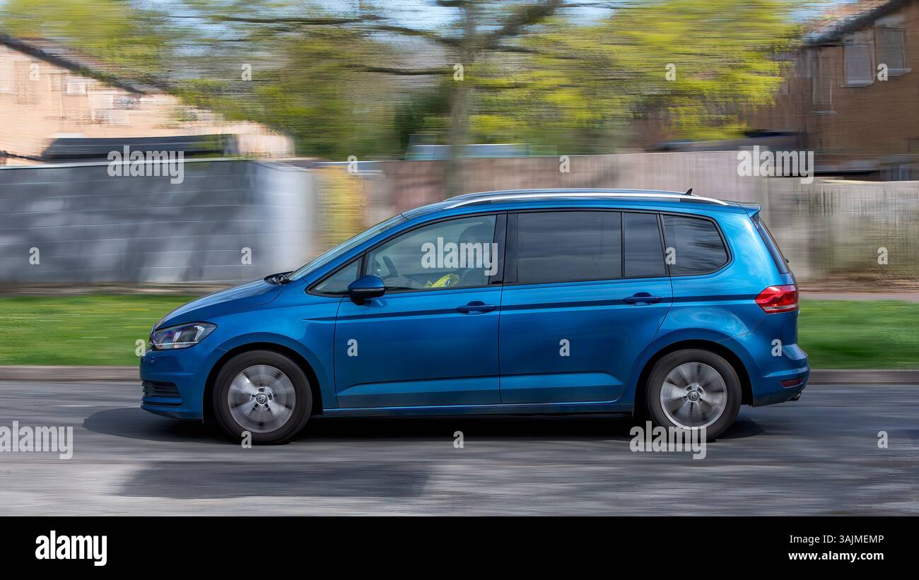 Milton Keynes, Regno Unito - 8 aprile 2025:2017 auto Volkswagen Touran monovolume blu che guida su una strada britannica Foto Stock