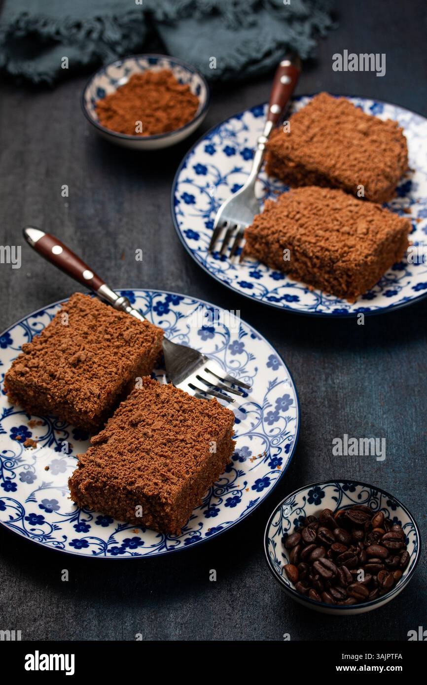 Torta al cioccolato umida con scaglie di cioccolato - stile Moody scuro su sfondo in legno Navy Foto Stock