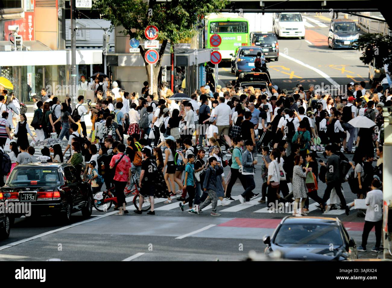 Vita quotidiana in Giappone Una scena di vacanza al Shibuya Scramble Crossing con molte persone che attraversano la strada Foto Stock