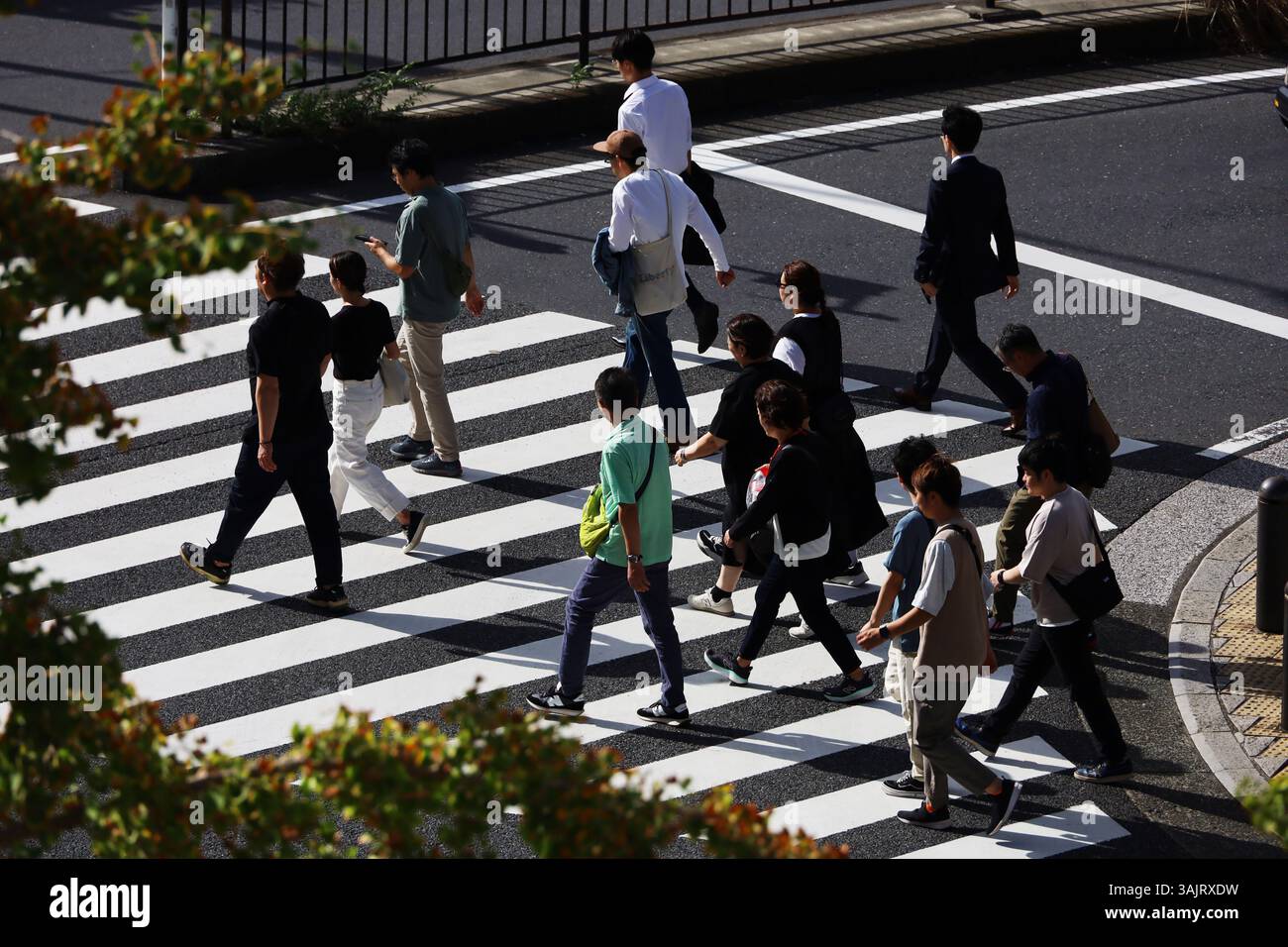 Vita quotidiana in Giappone Una scena da un incrocio a Yokohama Minato Mirai, dove la gente che si dirige verso i luoghi turistici attraversa la strada Foto Stock