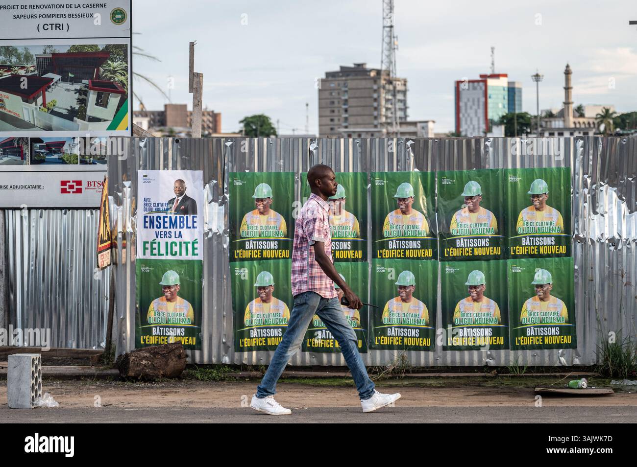 Libreville, Gabon. 10 aprile 2025. Un uomo passa davanti ai manifesti della campagna a Libreville, Gabon, il 10 aprile 2025. Il Gabon terrà le sue prime elezioni presidenziali sabato dopo un colpo di Stato di due anni fa, segnando la fase finale della transizione politica del paese e il previsto ritorno all'ordine costituzionale. Crediti: Wang Guansen/Xinhua/Alamy Live News Foto Stock