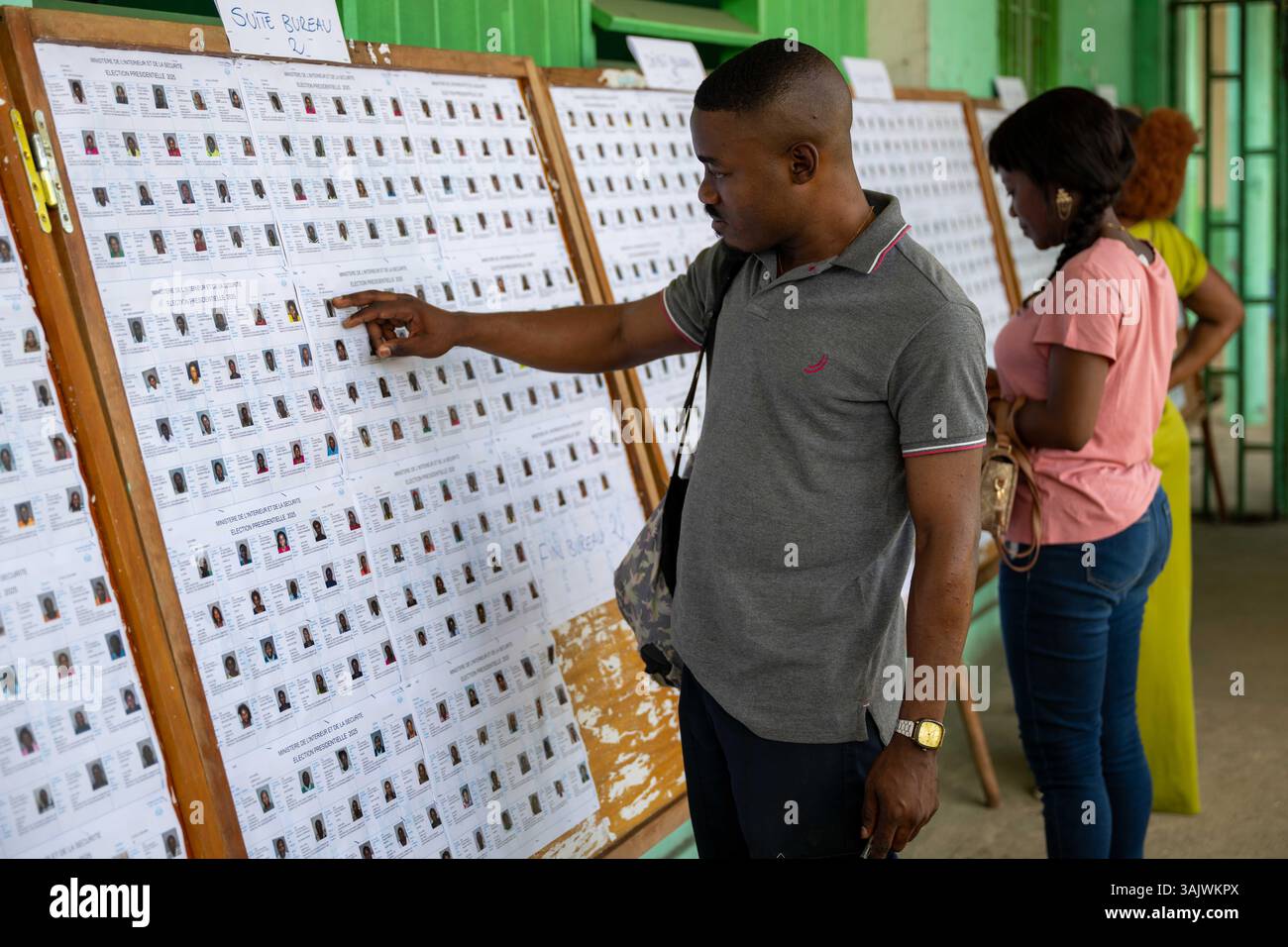 Libreville, Gabon. 11 aprile 2025. Le persone controllano le informazioni degli elettori in una stazione elettorale a Libreville, Gabon, l'11 aprile 2025. Il Gabon terrà le sue prime elezioni presidenziali sabato dopo un colpo di Stato di due anni fa, segnando la fase finale della transizione politica del paese e il previsto ritorno all'ordine costituzionale. Crediti: Zheng Yangzi/Xinhua/Alamy Live News Foto Stock