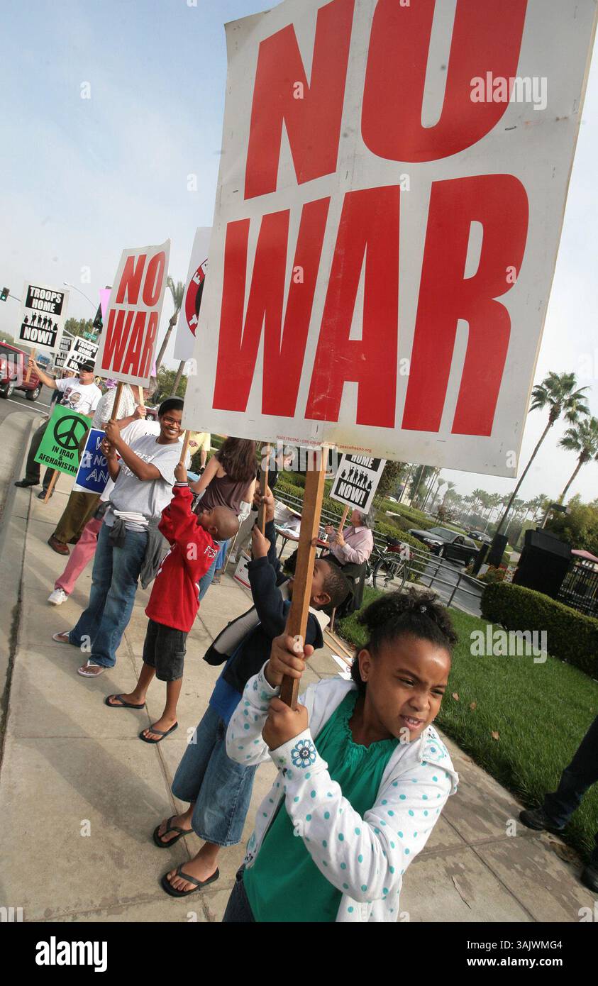 Fresno, CA 10-17-2009 - MTD JRW PACE NO WAR - Aubre (cq) Brown, 8, destra, si unisce ai manifestanti, tra cui sua madre Tosha Curls, sullo sfondo a sinistra, nel segnare 8 anni di guerra in Iraq e Afghanistan, a Blackstone ed El Paso al centro commerciale River Park, sabato mattina. John Walker/The Fresno Bee (immagine di credito: © Fresno Bee/ZUMApress.com) Foto Stock
