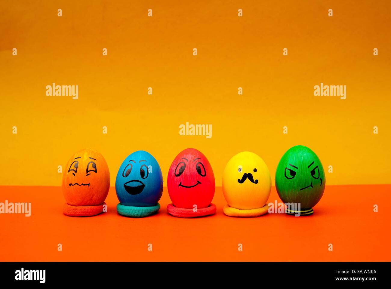 Uova di emoji colorate in fila per una foto allegra e giocosa di Pasqua. Volti creativi dell'uovo di Pasqua con espressioni divertenti Foto Stock