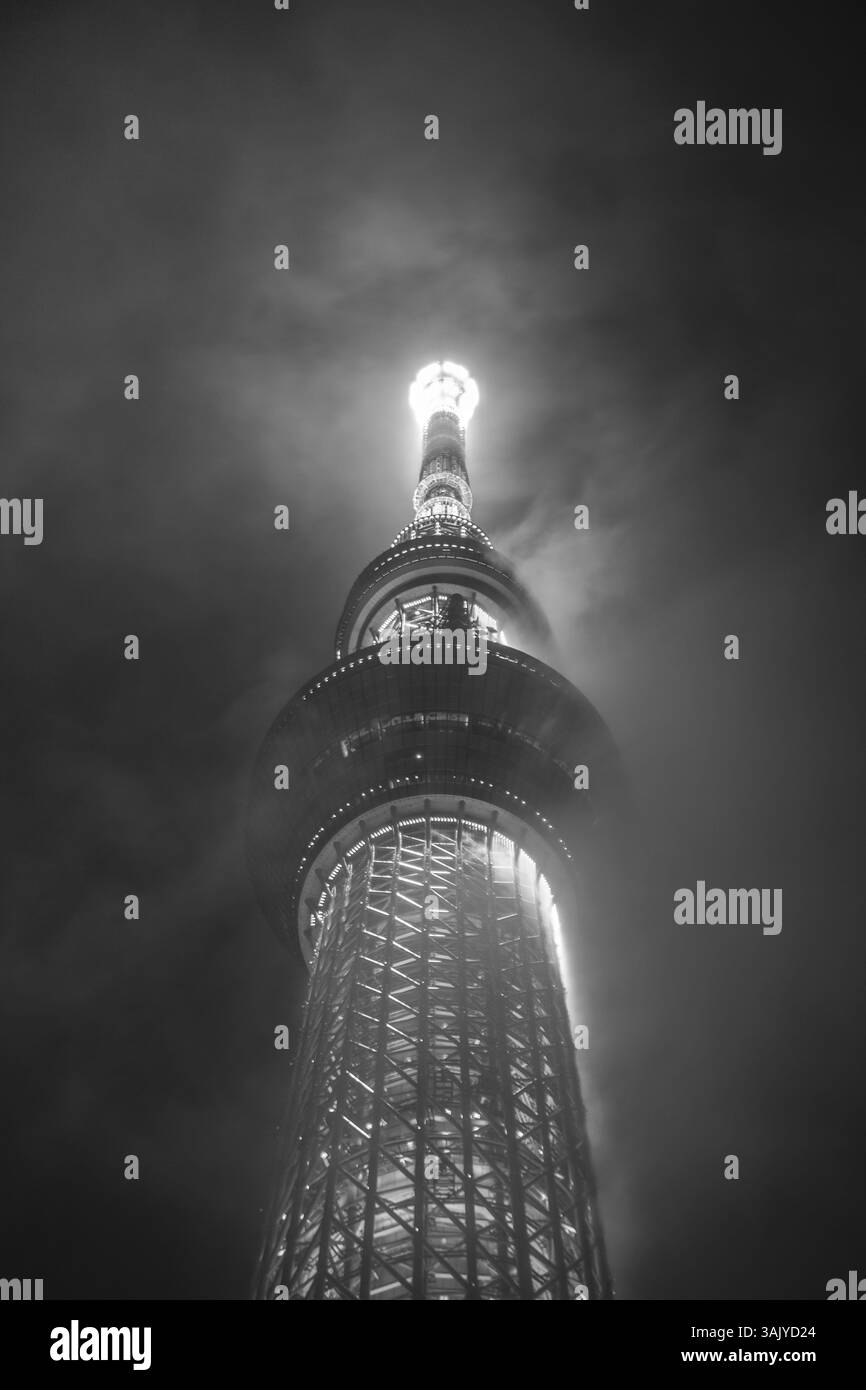 Tokyo Skytree che brilla attraverso le nuvole di notte, visto dal basso ad Asakusa, in Giappone Foto Stock