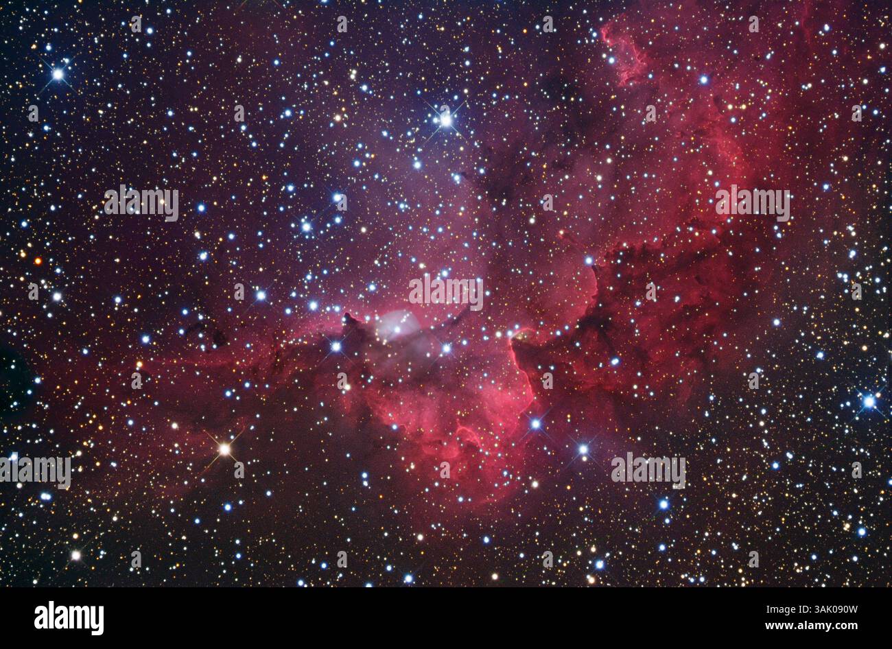 Nebulosa di emissione SH2-142, immagine ottica. La nebulosa di emissione SH2-142 è associata all'ammasso stellare aperto NGC 7380 (le stelle più luminose viste qui). La nebulosa si illumina di rosso quando le radiazioni provenienti dalle stelle appena formate ionizzano il gas idrogeno che contiene. La nebulosa e l'ammasso si trovano a circa 7000 anni luce dalla Terra, nella costellazione Cefeo. Foto Stock