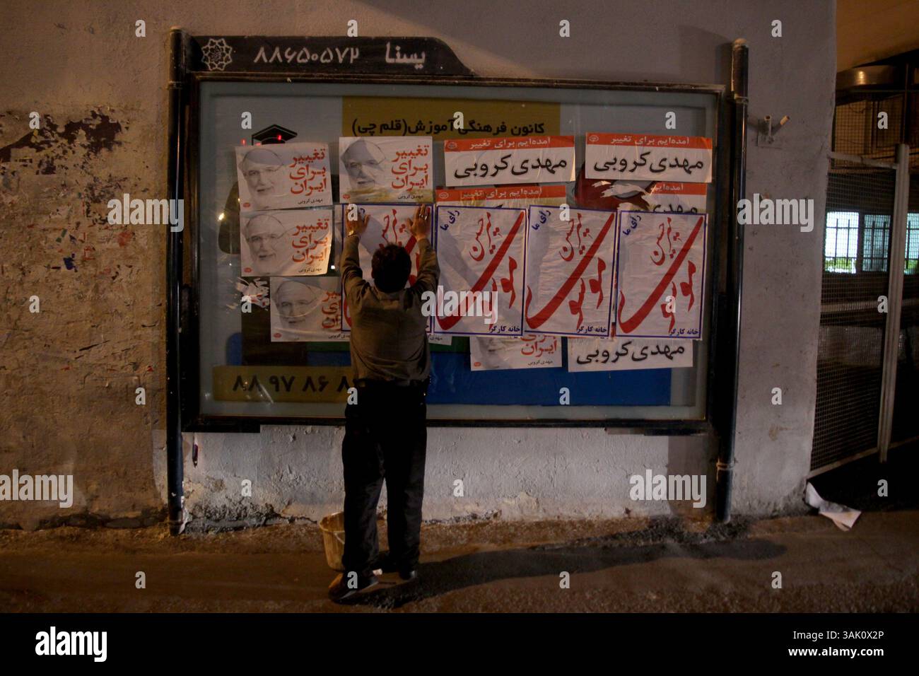 28 maggio 2009 - Teheran, Iran - Un sostenitore del candidato alle elezioni presidenziali, Mir Hossein Mousavi, incolla manifesti su un cartellone a Teheran. (Immagine di credito: © Roshan Norouzi/ZUMA Press) Foto Stock