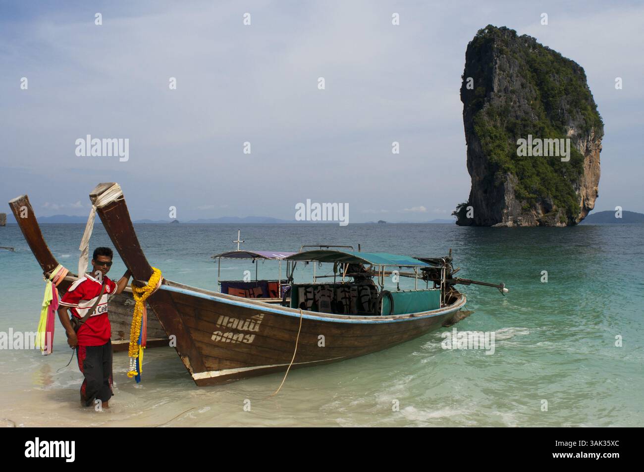 20 agosto 2009 - Thailandia - barca a coda lunga ormeggiata sulla spiaggia delle isole Koh Poda nel Mare delle Andamane, Thailandia. Ko Poda è un'isola al largo della costa occidentale della Thailandia, nella provincia di Krabi, a circa 8 chilometri da Ao Nang. Fa parte delle isole Mu Ko Poda, o Poda Group Islands, che sono sotto l'amministrazione del Parco nazionale Hat Nopharat Thara-Mu Ko Phi Phi. Il gruppo è composto da Ko Poda, Ko Kai, Ko Mo e Ko Thap. Il MU Koh Poda include Koh Poda, Koh Kai, Koh Thab e Koh Mo, le quattro isole per un tour di un giorno che è il programma di tour più popolare di Krabis. È un viaggio comodo per toccare il WO Foto Stock