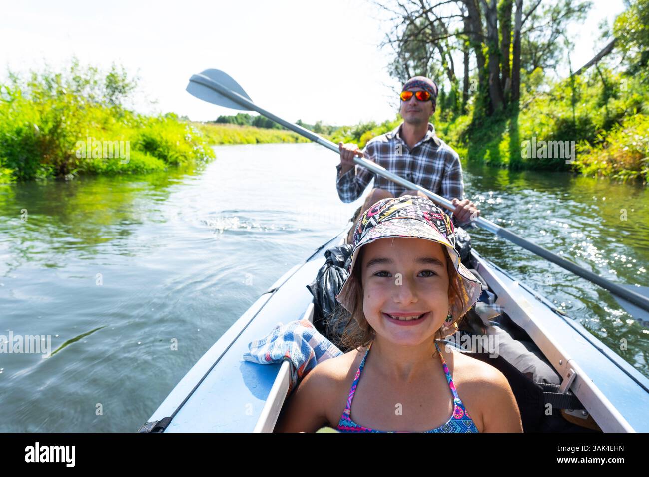 Gita in kayak in famiglia. Una barca a remi per padre e figlia sul fiume, un'escursione in acqua, un'avventura estiva. Eco-friendly e turismo estremo, attivo e salute Foto Stock
