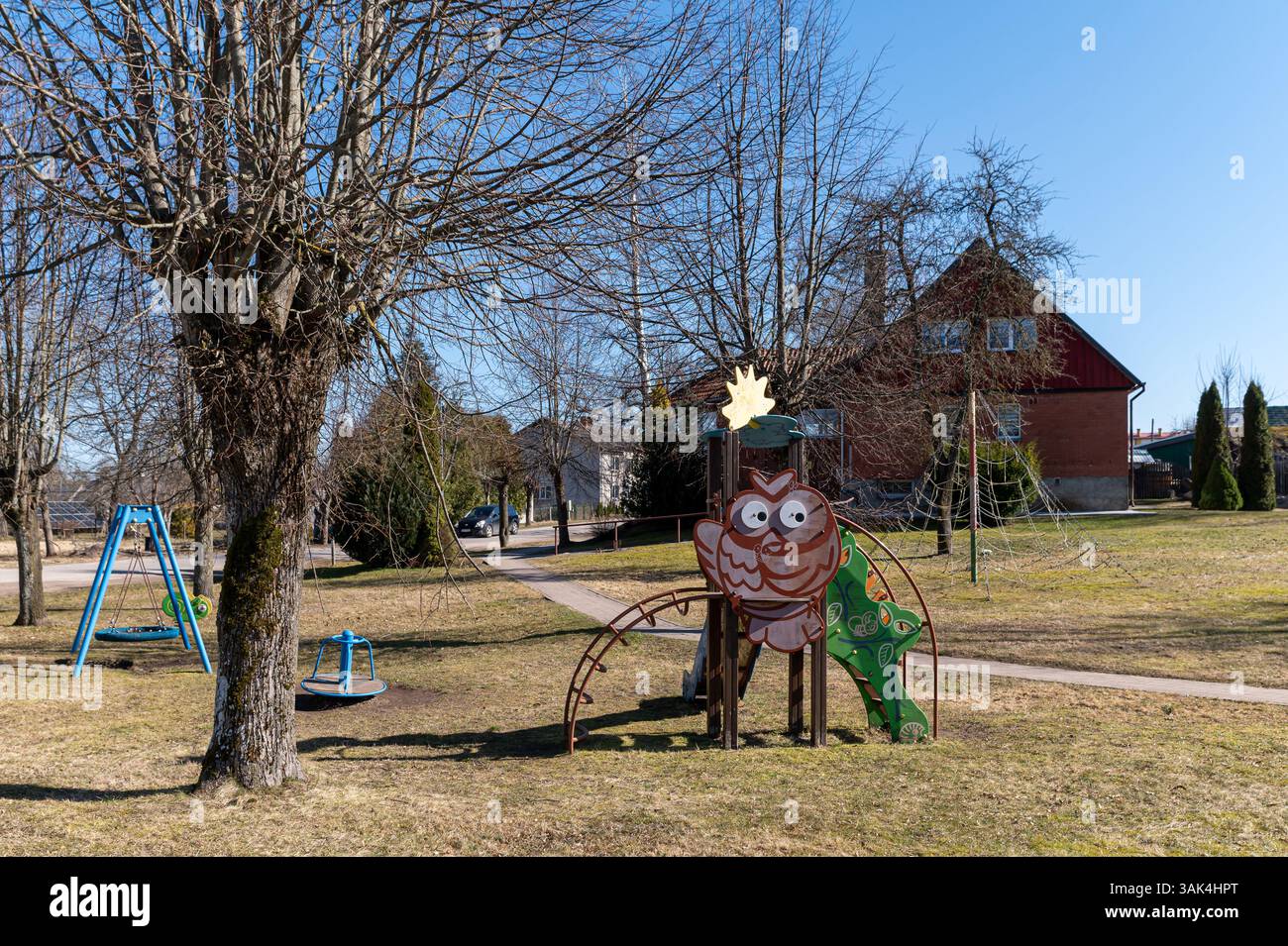 La struttura del parco giochi dei gufi dai colori vivaci offre gioia ai bambini in un parco soleggiato. Foto Stock