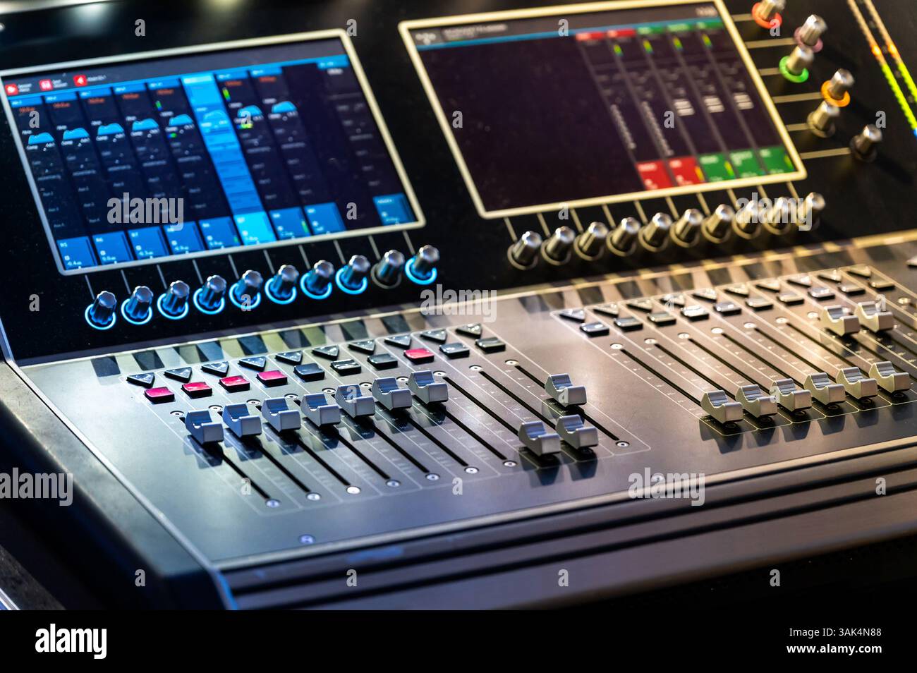Mixer audio digitale professionale con comandi e display illuminati in uno studio di registrazione Foto Stock