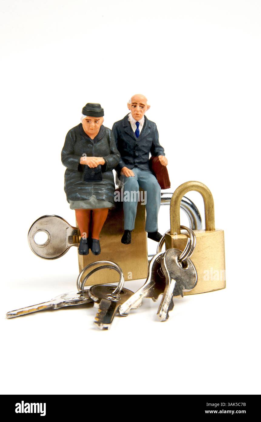 Due figure in miniatura sono posizionate su un lucchetto in ottone, nel profondo della conversazione. Varie chiavi sono sparse in giro, aggiungendo un contesto alla loro discussione, Foto Stock