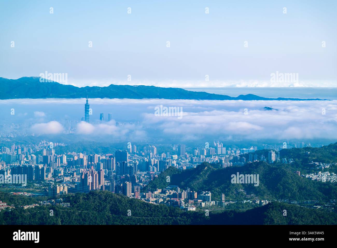 Osserva una città che emerge da un mare di nuvole. Un'alba surreale di primavera dalla montagna Lion Head, Taiwan, dove i sogni incontrano la realtà. Foto Stock