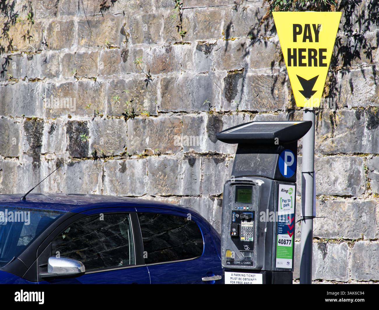Paga qui il cartello giallo nel parcheggio pubblico Foto Stock