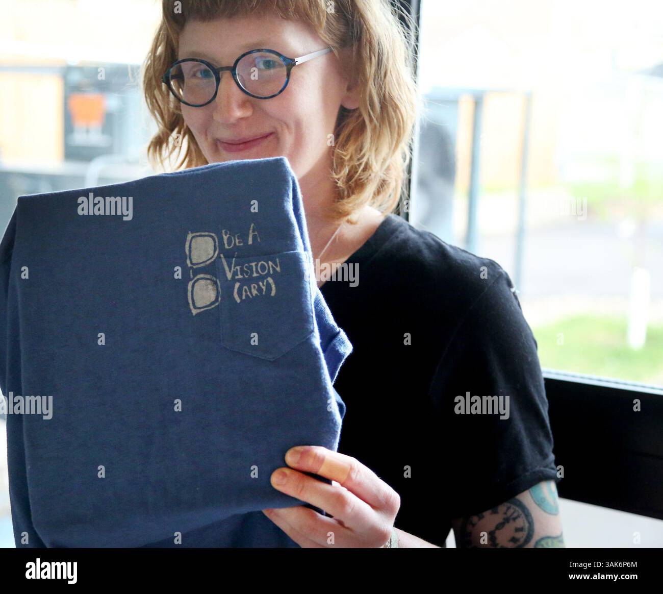 29 aprile 2017 - Minneapolis, Minnesota, Stati Uniti - Fashion Revolution MN ha ospitato "upcycling" Your Clothes, un evento in cui gli ospiti hanno scelto un vecchio tee da portare in casa e lo hanno stampato in diretta con un design femminista realizzato appositamente per l'evento alla Twin Spirits Distillery il 29 aprile 2017, a Minneapolis. Qui, l'artista serigrafica Sarah Mering, di Minneapolis, con una camicia appena stampata e il suo design all'evento. (Immagine di credito: © David Joles/TNS via ZUMA Wire) Foto Stock