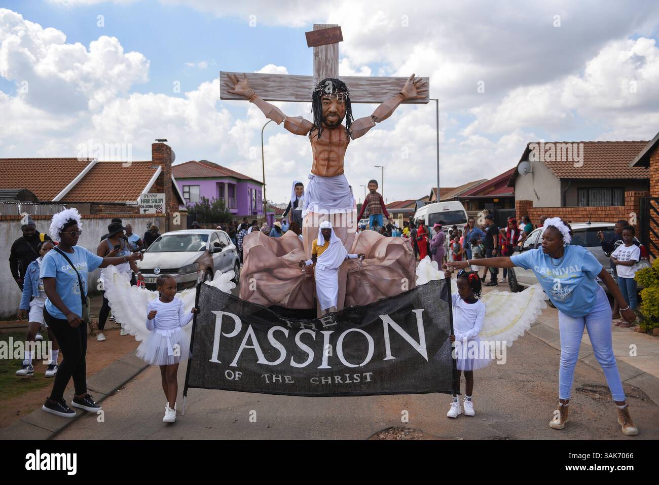 The Passion of the Christ Production in Sud Africa i partecipanti partecipano alla Passion of the Christ Parade, una collaborazione tra la scuola ECD per lo sviluppo della prima infanzia Kiddies Hope Academy e la Nkosana Ngobese Foundation attraverso le strade di Dobsonville, Soweto, Sud Africa 12 aprile 2025. La passione della produzione di Cristo è una rappresentazione drammatica dell'ultimo giorno della vita di Gesù, culminante nella crocifissione. La produzione presentava bambini di 5 e 6 anni in costumi, vestiti da angeli, Gesù che trasportava una croce e soldati romani, oltre a marionette giganti che interpretavano il ruolo di Jesu Foto Stock