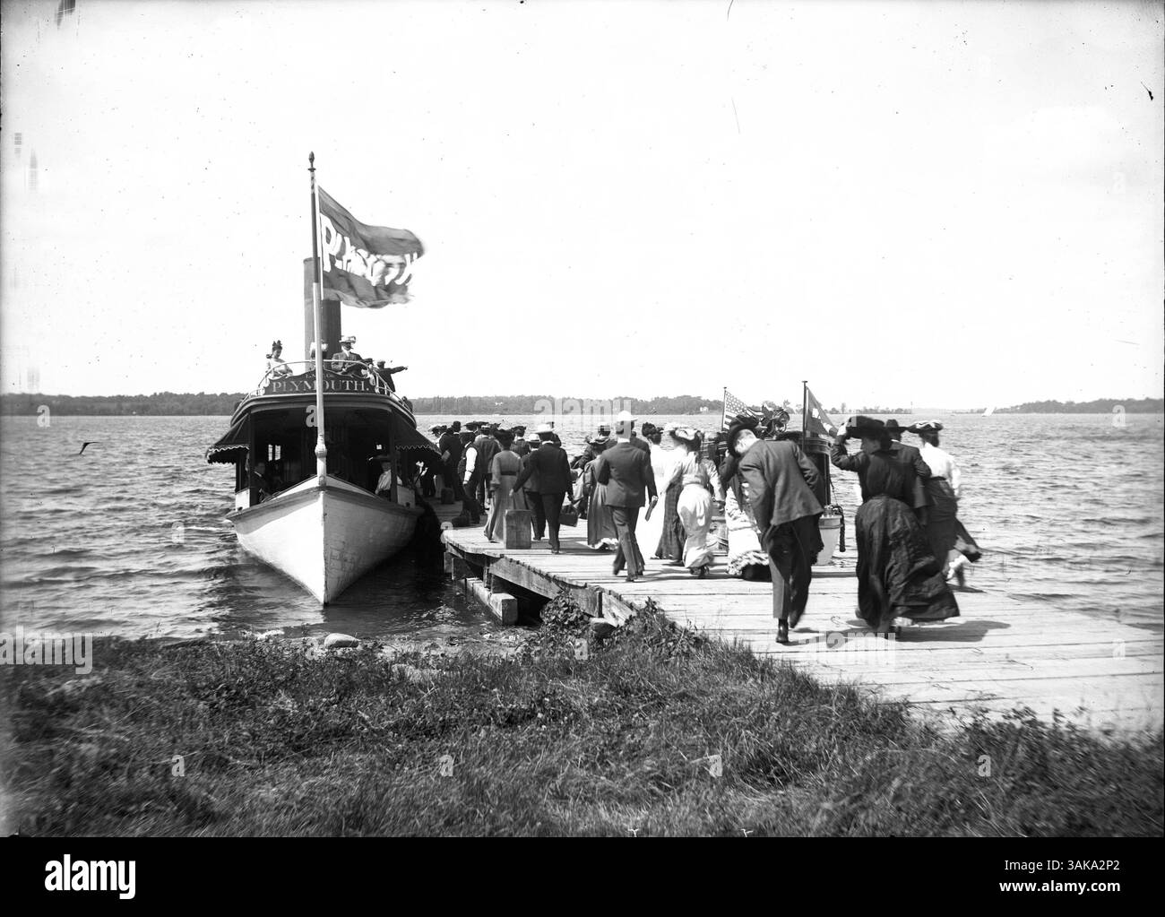Il piroscafo 'Plymouth' si vede a Tonka Bay, sul lago Minnetonka, con un gruppo di persone a bordo della barca. Un altro piroscafo più piccolo è attraccato nelle vicinanze, parzialmente oscurato dalla folla. Foto Stock