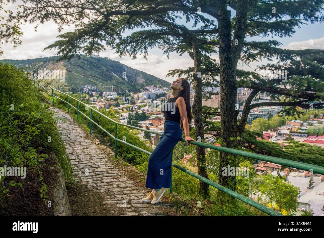 Giovane donna enjoyi/ng primavera a Tbilisi. Ci sono splendidi sentieri sul monte sopra la capitale georgiana (città vecchia). Si sta alzando, gli ha ributtato la testa Foto Stock