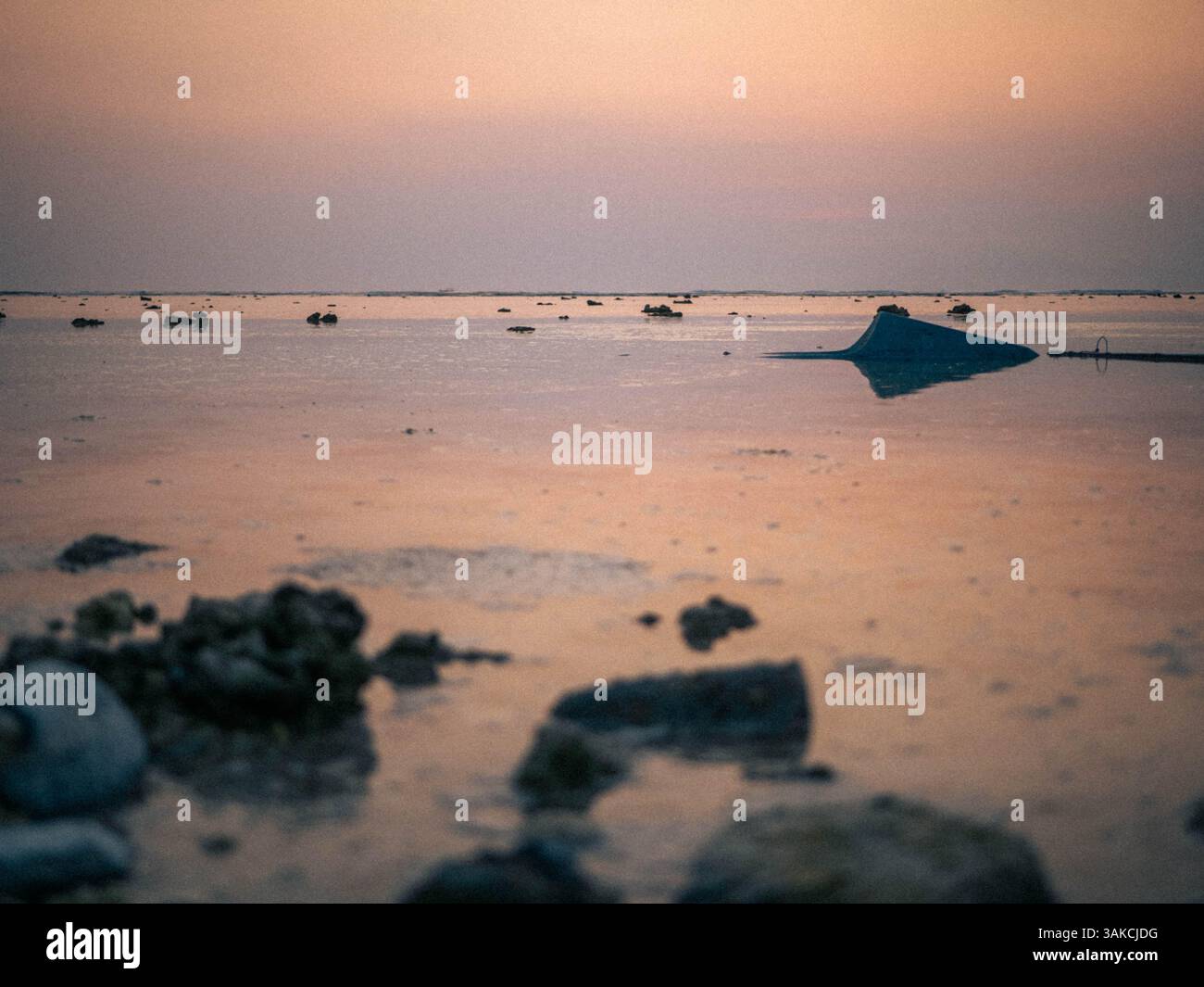 Tramonto panoramico sulle acque calme con Rocks and Reflections Foto Stock
