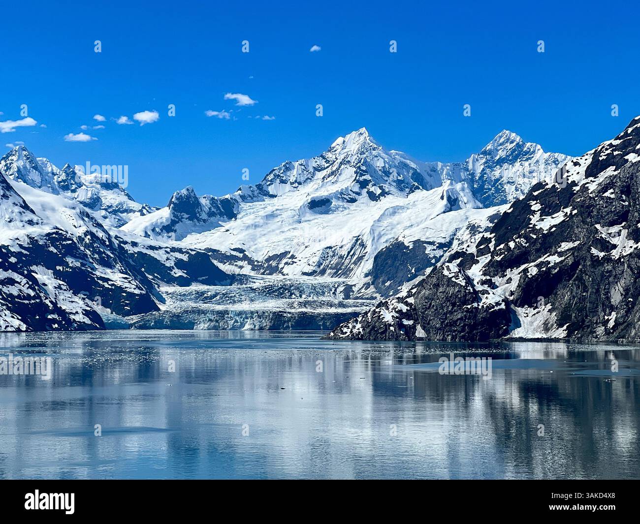 Una vista mozzafiato del Parco Nazionale di Glacier Bay, dove torreggianti cime innevate si riflettono sulle acque cristalline. Una vera testimonianza dell'untouc - Immagine stock catturata con smartphone