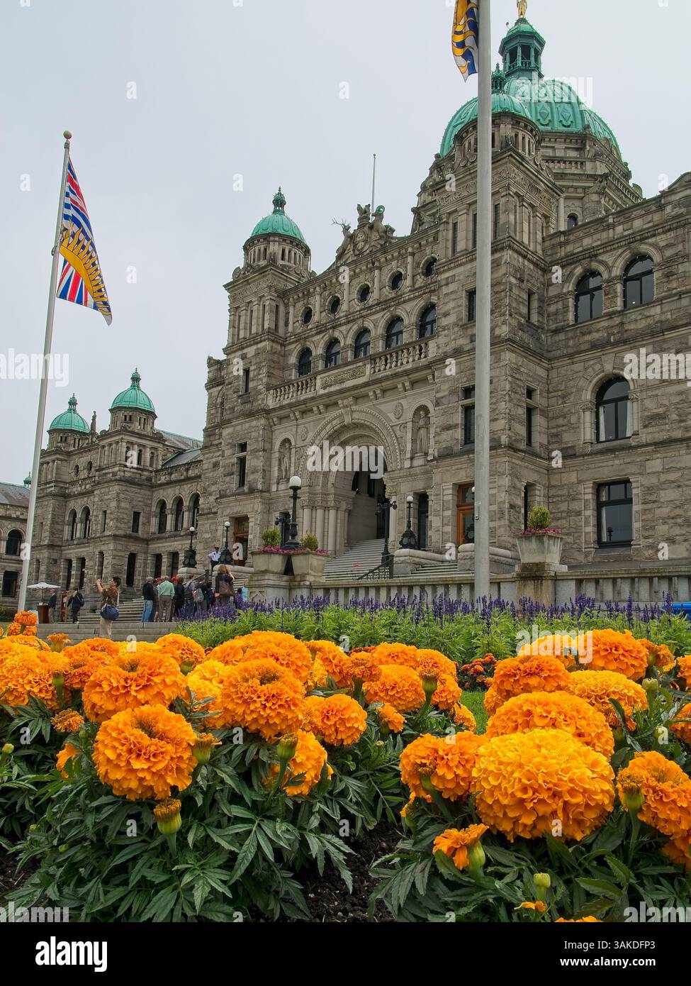 1898 edifici in stile neo-barocco del Parlamento della Columbia Britannica sotto il cielo coperto incorniciati da luminosi aiuole di fiori a Victoria, Isola di Vancouver Foto Stock