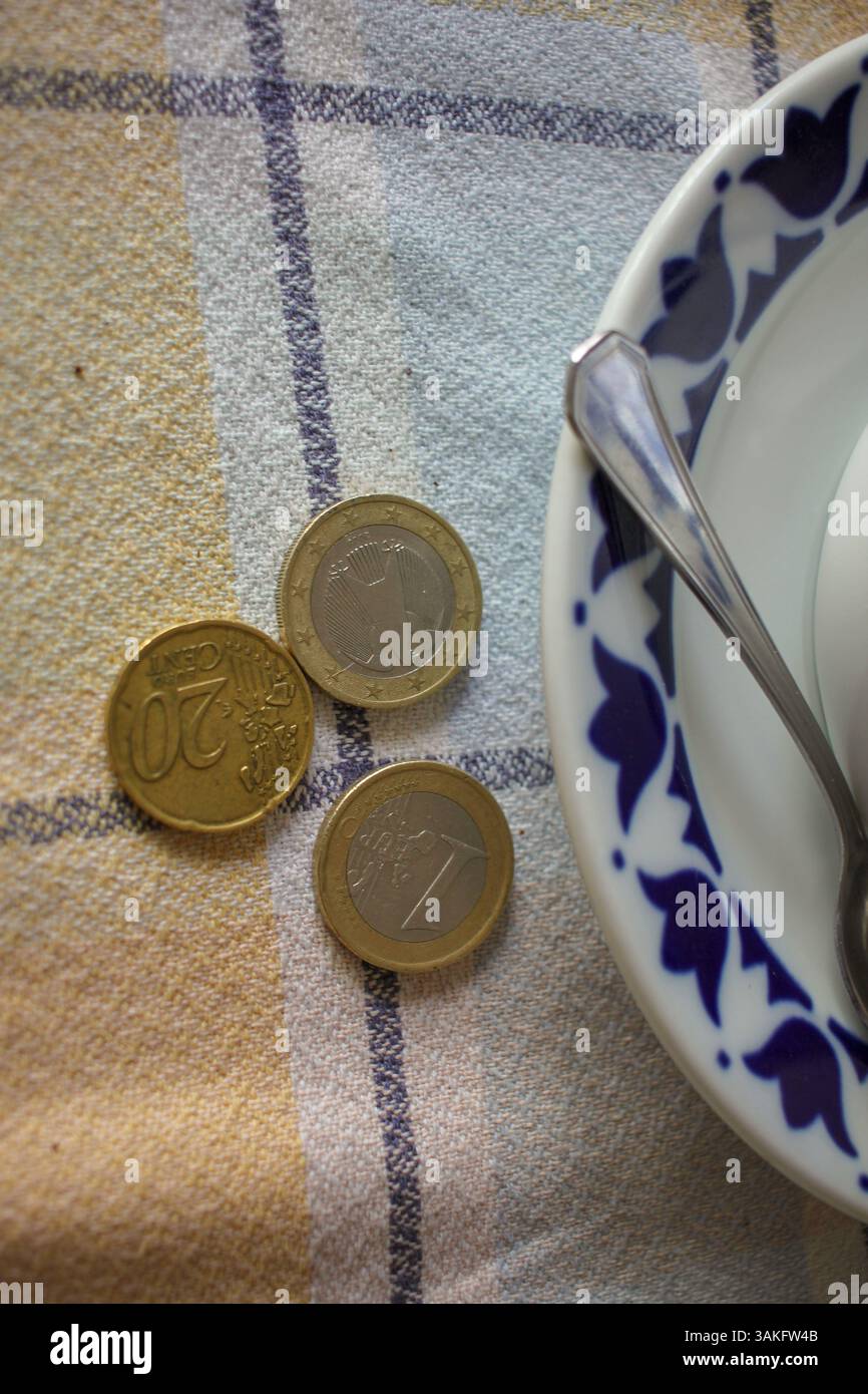 tazza di caffè e monete sul tavolo. Aumento dei prezzi Foto Stock