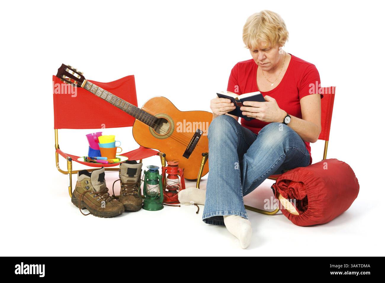 Senior donna è la lettura di un libro presso il campeggio Foto Stock