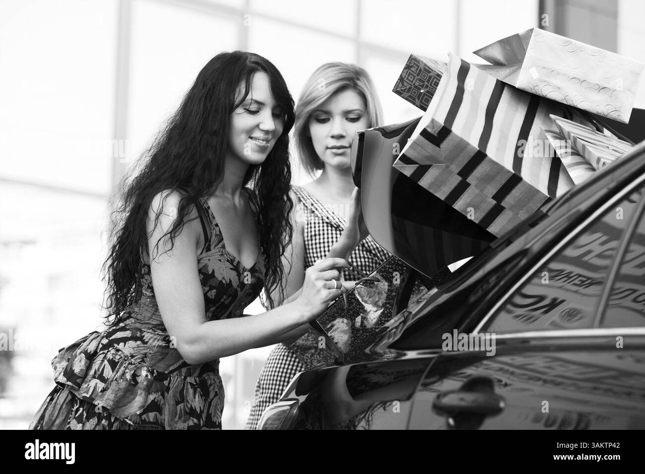 Ragazza-amici dopo lo shopping mette le loro borse in linea Foto Stock