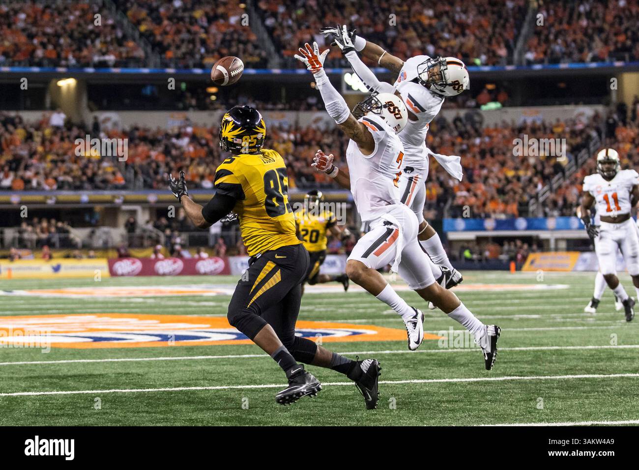 3 gennaio 2014 - Arlington, Texas, Stati Uniti d'America - 3 gennaio 2014: Il wide receiver dei Missouri Tigers Marcus Lucas (85) riceve un passaggio per un touchdown con la safety degli Oklahoma State Cowboys Shamiel Gary (7) in difesa durante la partita di football NCAA dell'AT&T Cotton Bowl Classic tra gli Oklahoma State Cowboys e i Missouri Tigers all'AT&T Stadium di Arlington, Texas. I Tigers sconfissero i Cowboys 41-31.(Credit Image: © Tim Warner/Cal Sport Media/ZUMAPRESS.com) Foto Stock