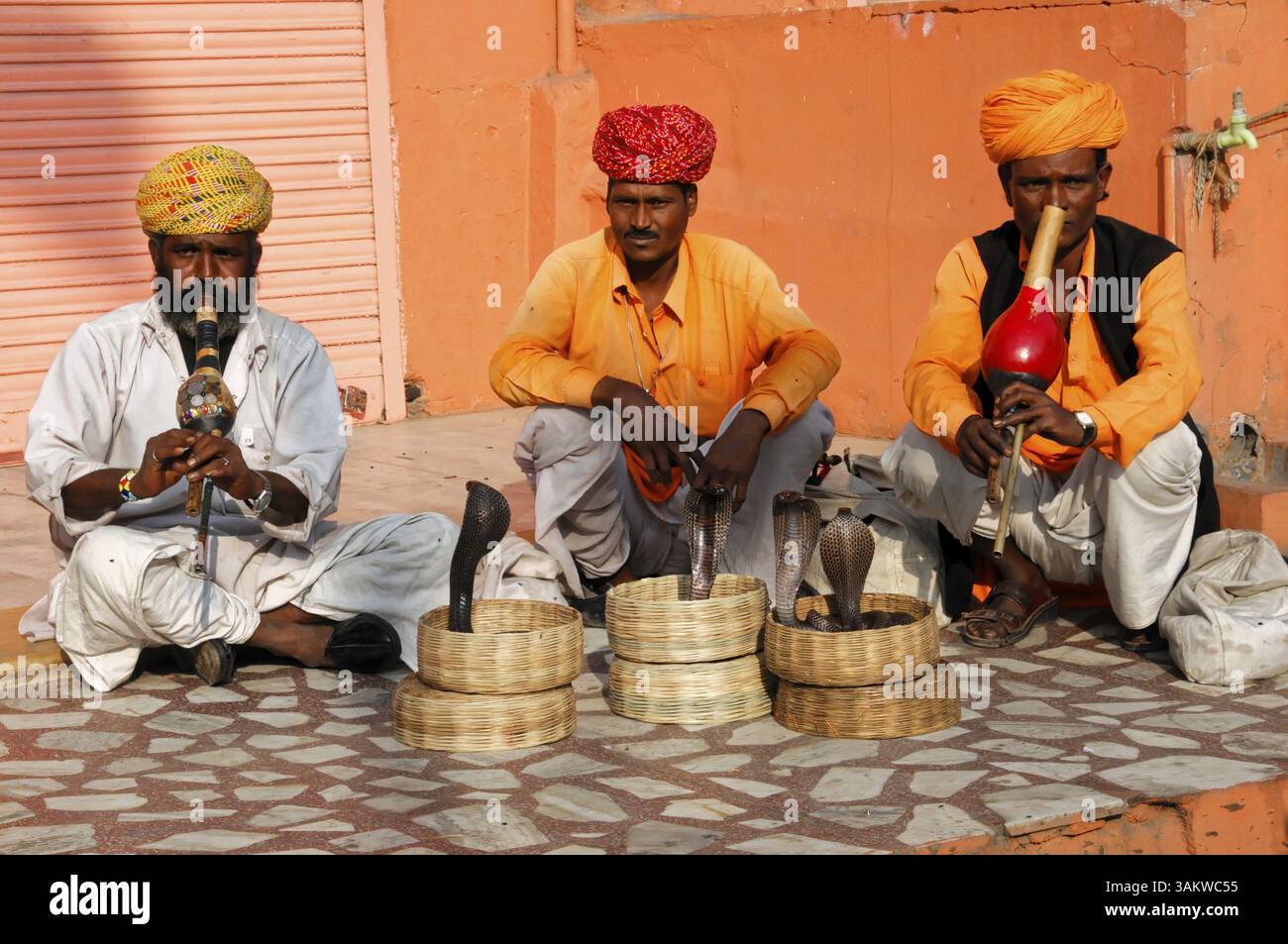 Jaipur, Rajasthan, India settentrionale, India, Asia, tre uomini in abito tradizionale che suonano strumenti incantatori di serpenti per strada, in Asia Foto Stock
