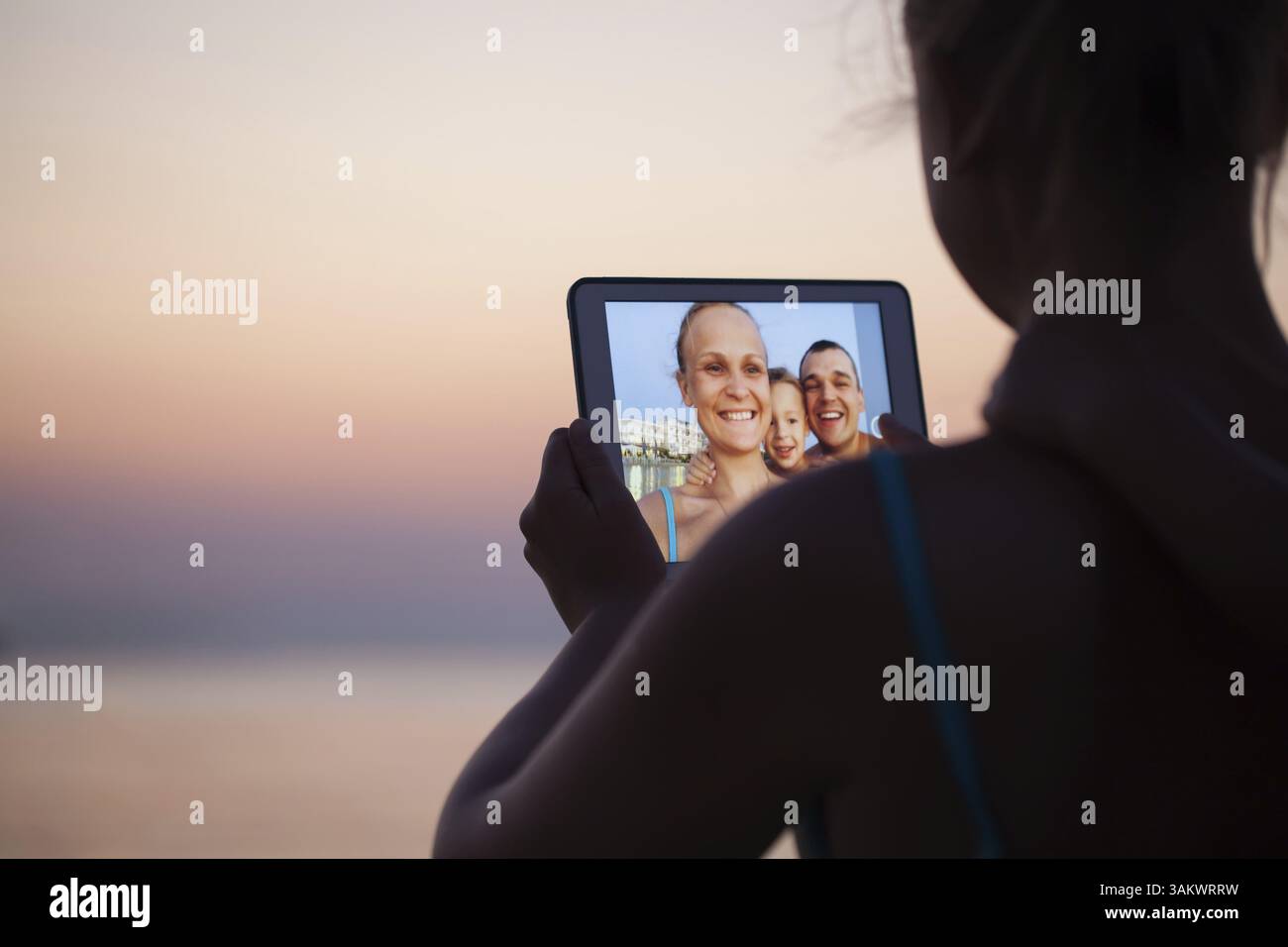 Madre, padre e figlio facendo selfie utilizzando computer tablet. Essi prendendo immagine sullo sfondo resort Foto Stock