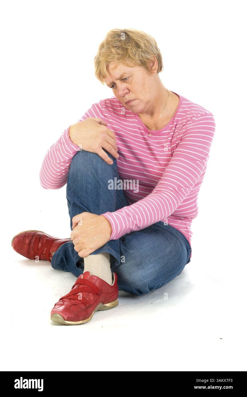 Donna anziana depressa seduta a terra Foto Stock