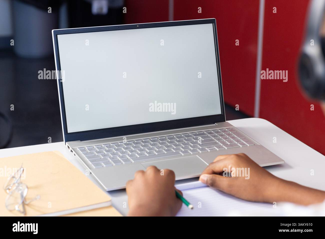 Utilizzando un computer portatile, uno studente scrive sul notebook durante la sessione di studio scolastica, copia spazio Foto Stock