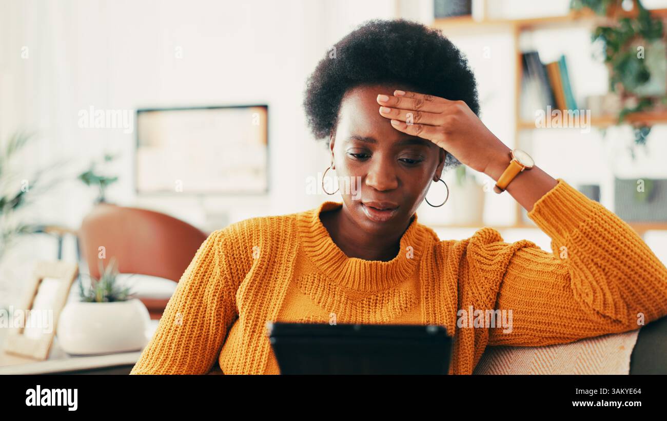 Donna nera, tablet e stress sul divano di casa per cattive notizie, recessione o crisi finanziaria per l'economia. Persona, mal di testa e frustrata Foto Stock